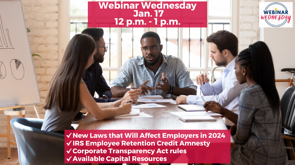 A multi-ethnic group of 5 employees are in a meeting at a rectangular table. The boss leading the meeting is a 35-year-old African-American man.